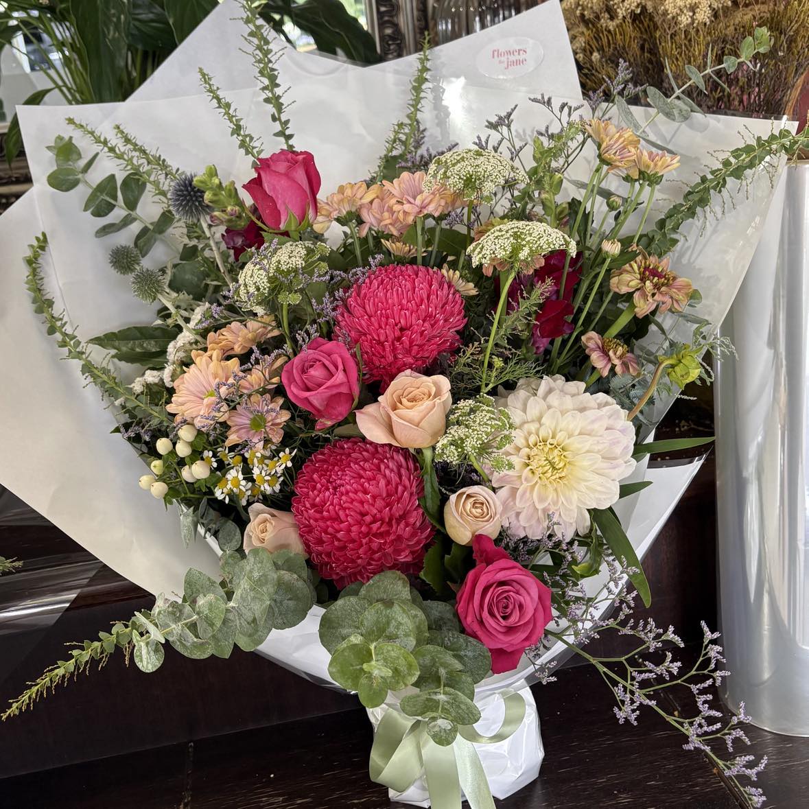 Bouquet of flowers with pink and white flowers on a wooden surface