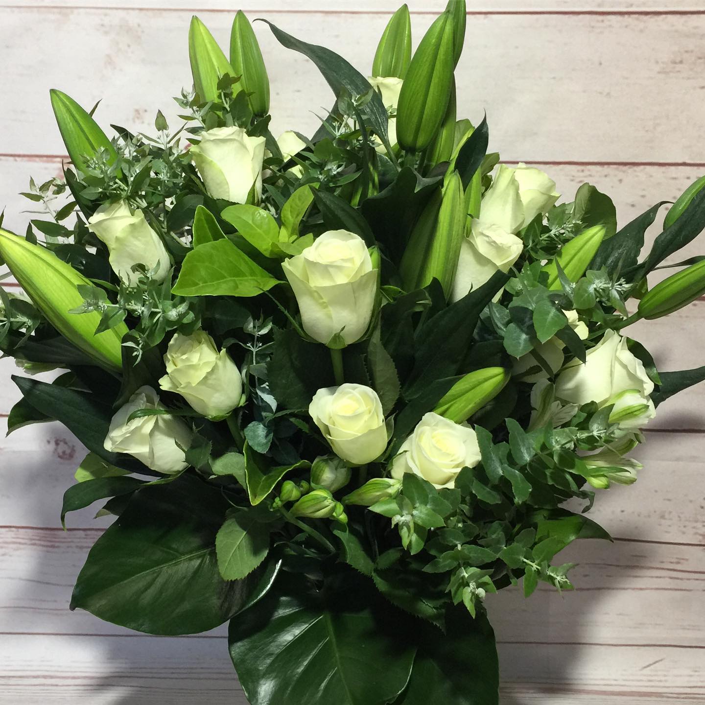 
                  
                    Bouquet of white roses with green leaves
                  
                